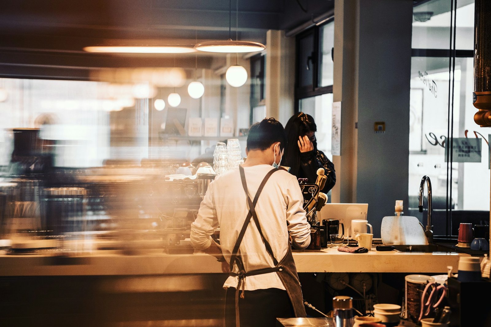 People working behind the counter of a small restaurant