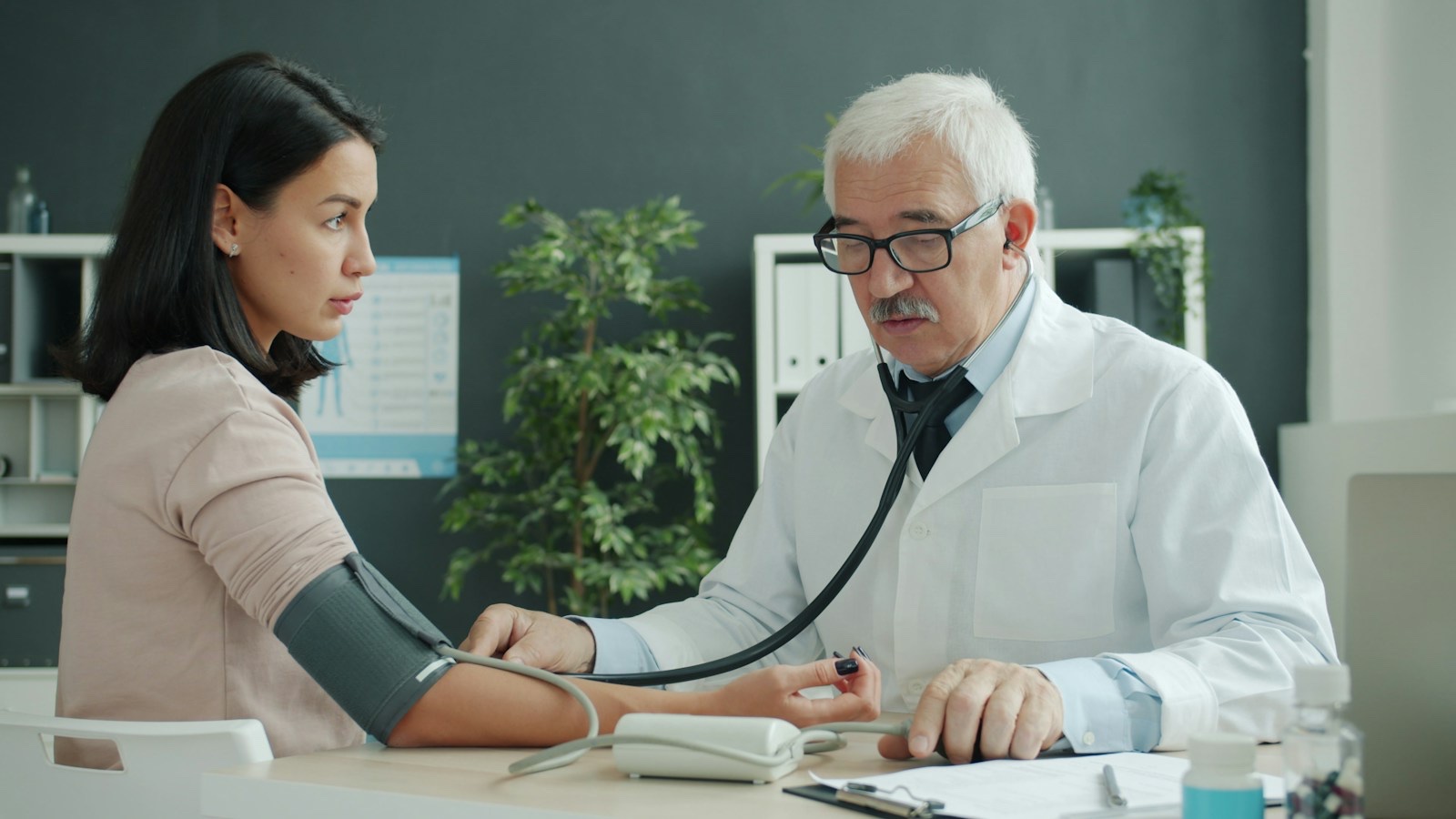 Doctor measuring a patient's blood pressure at a routine check-up
