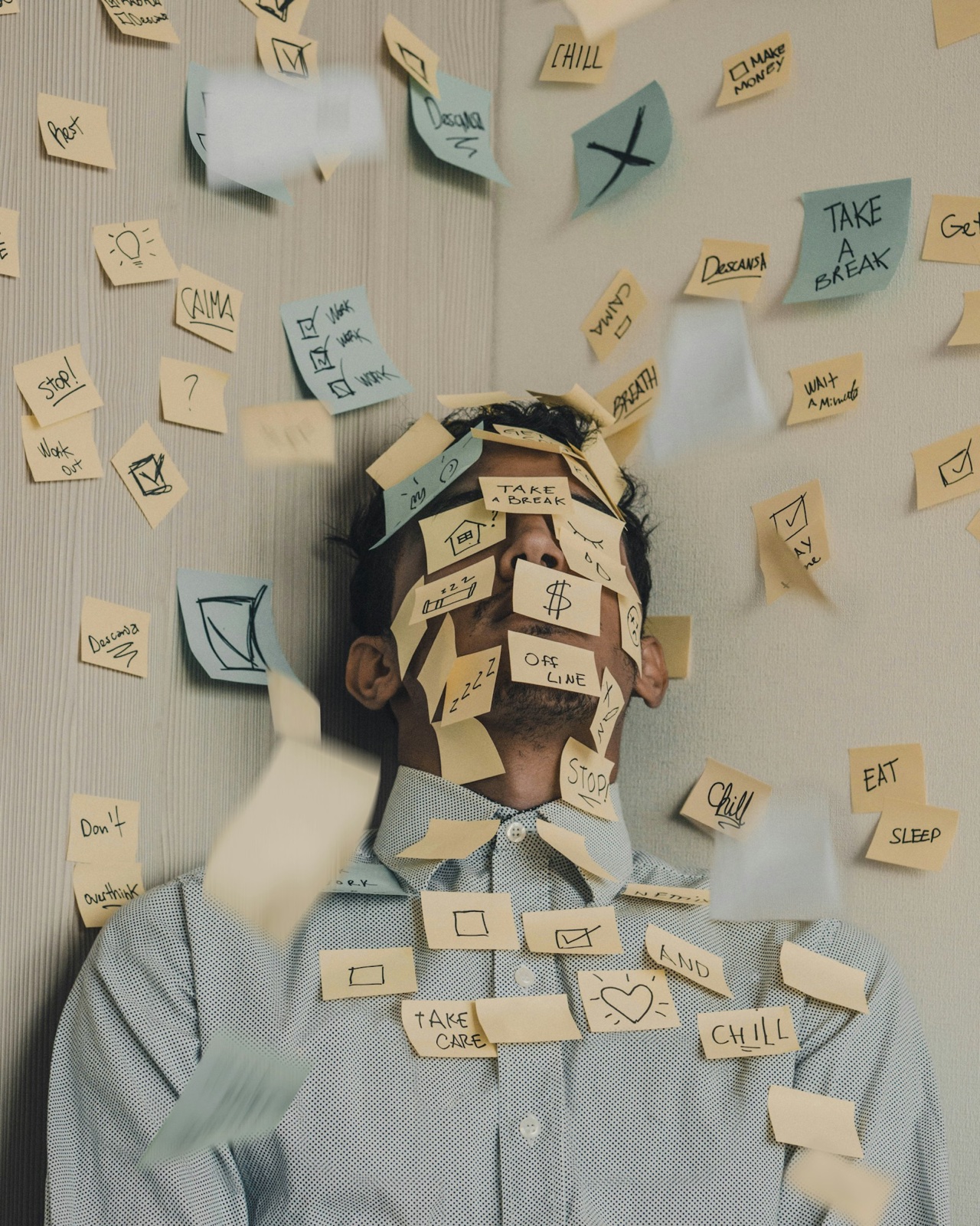 Person whose face is covered in sticky notes, illustrating the exhaustion of constant people-pleasing