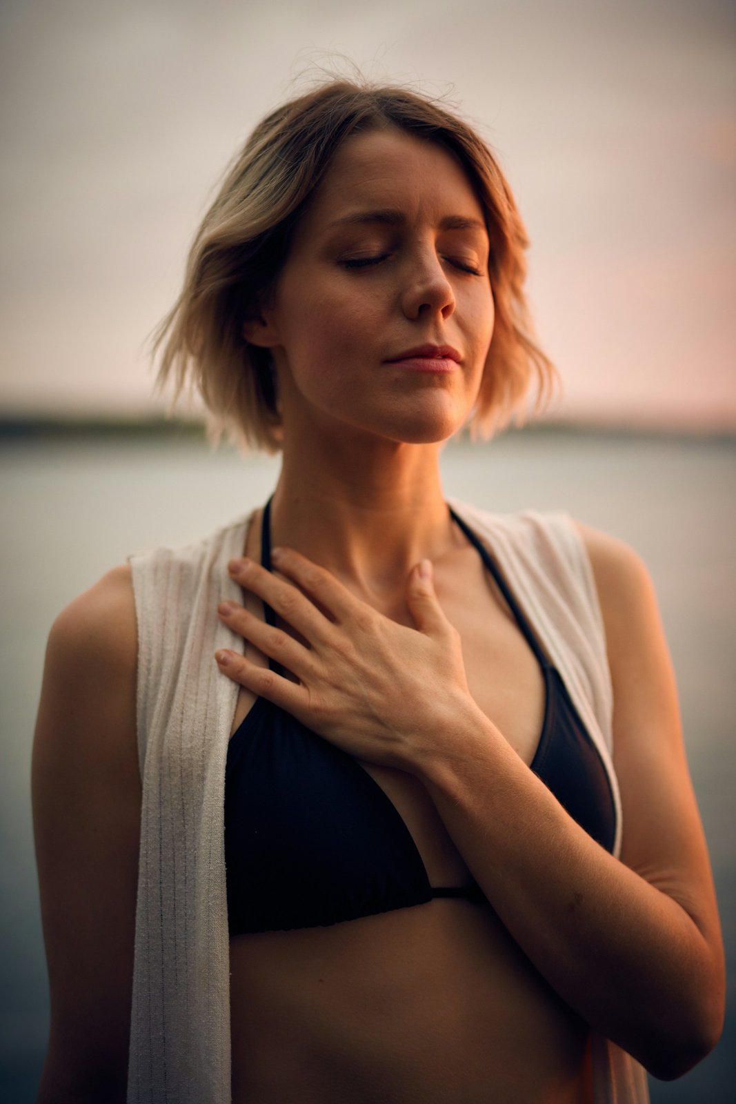 Woman with eyes closed and a hand on her chest, looking calm and at peace