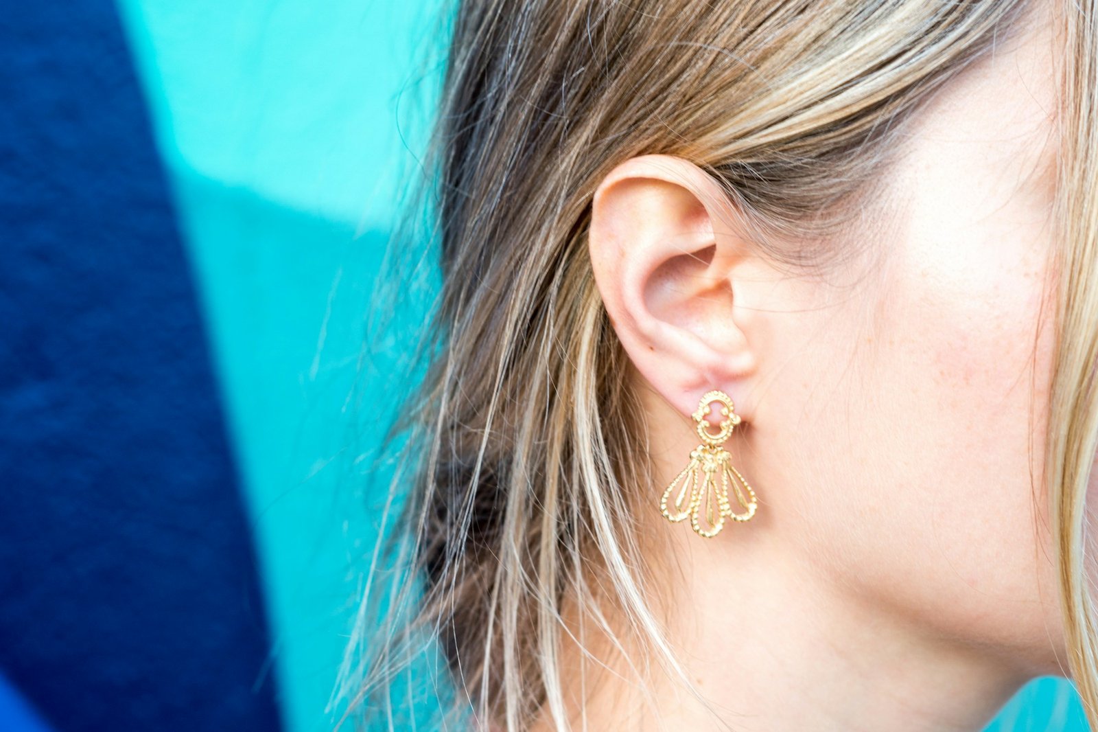 Close-up of a woman's ear with a gold earring