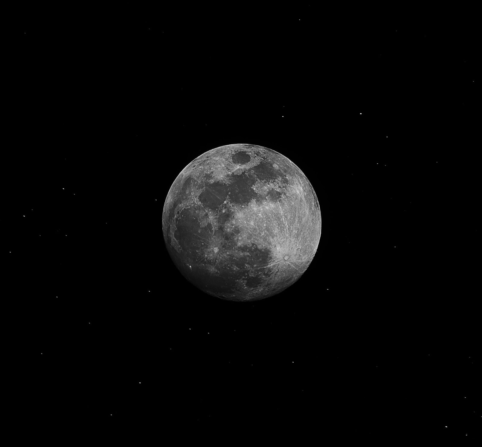 Full moon in a dark, starry night sky