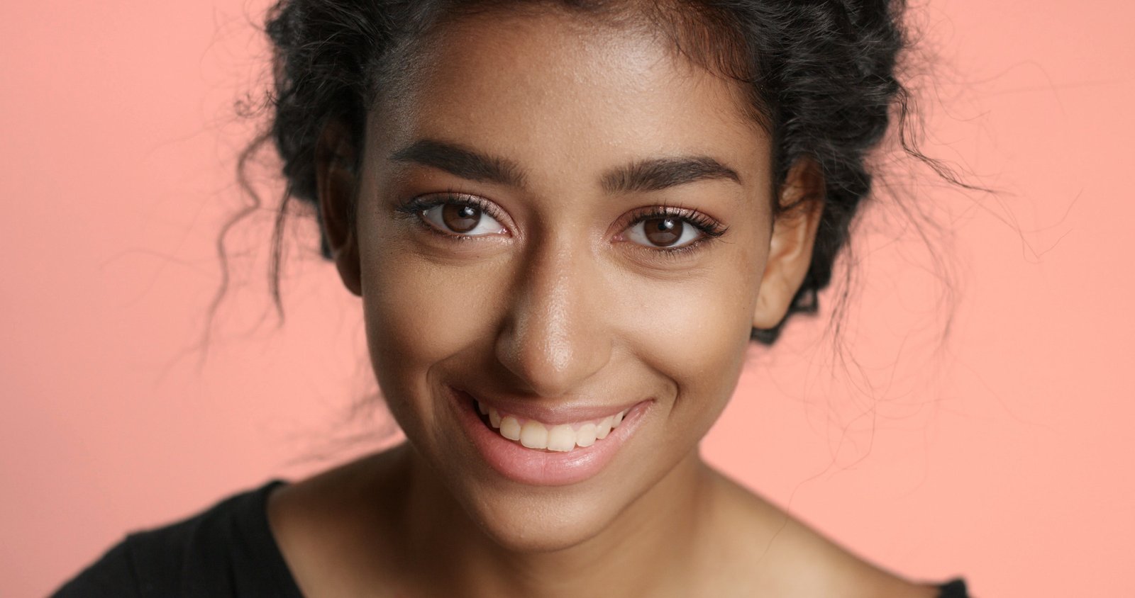 Smiling woman with an even, radiant, warm complexion