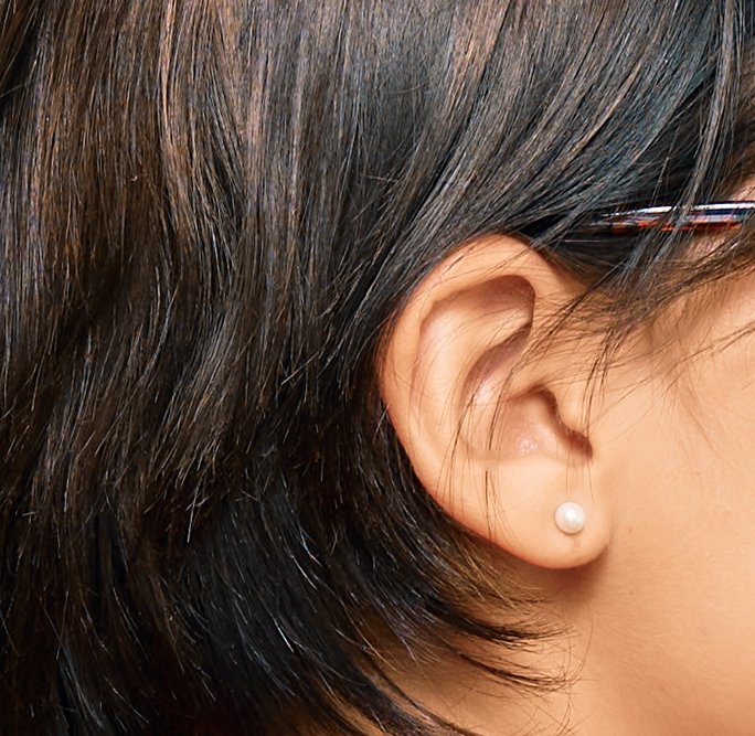 Close-up of an ear with a pearl stud earring