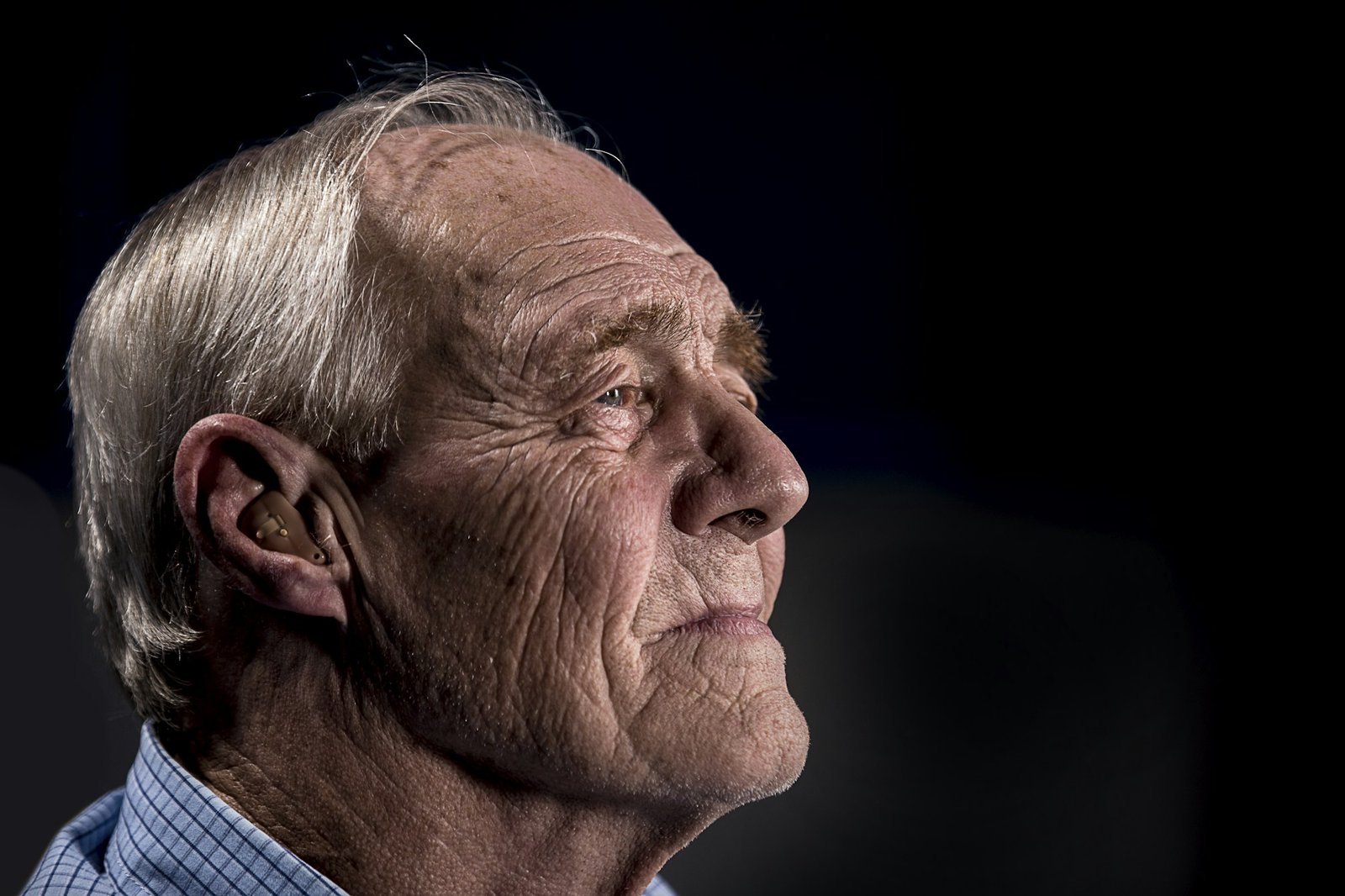 Elderly man in profile looking up with a calm, contented expression