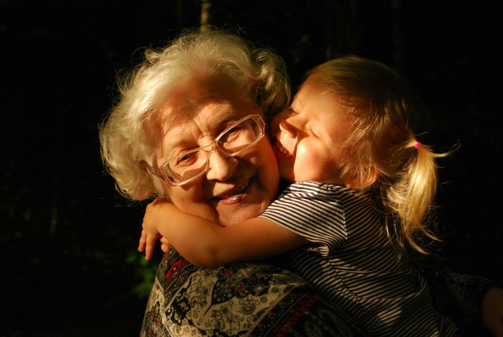 Grandmother hugging her young granddaughter