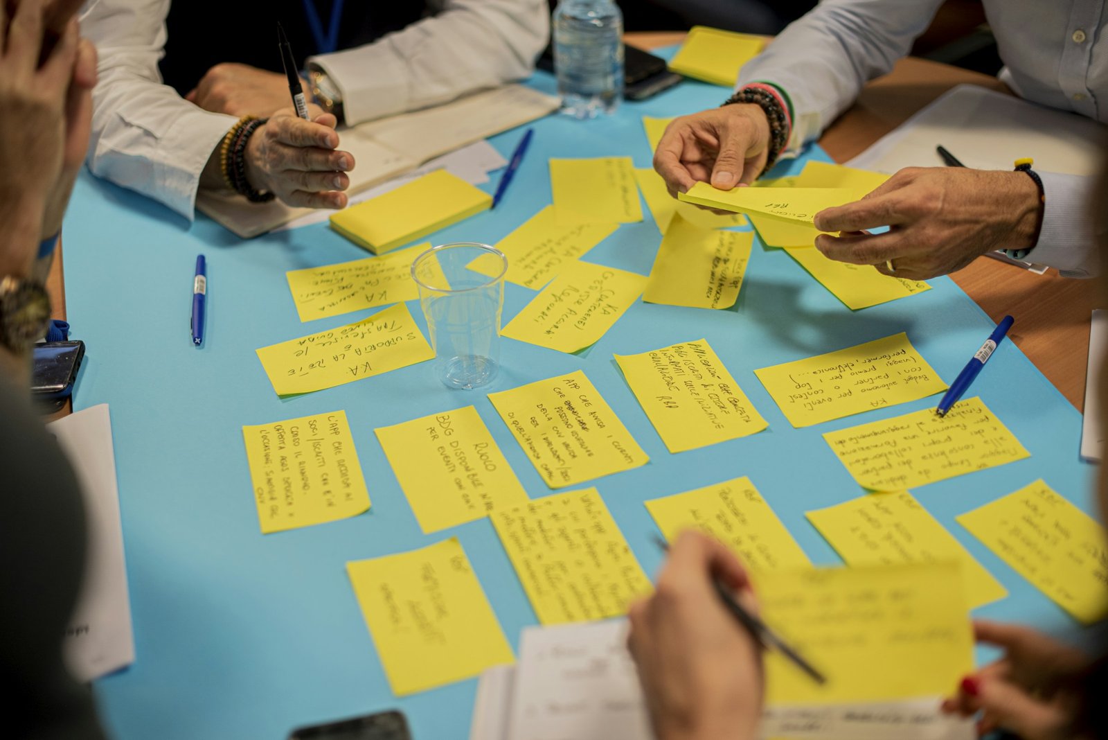 Team members arranging yellow sticky notes during a planning session