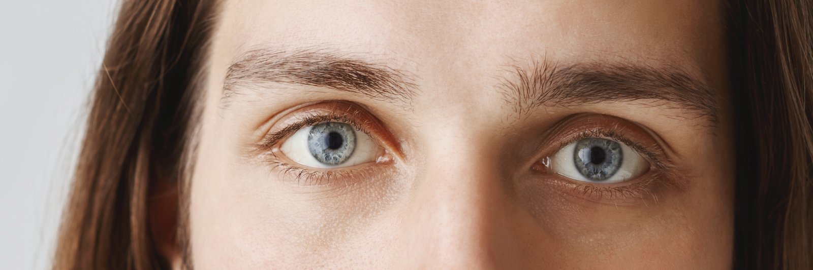 Close-up of intense blue eyes with brows set low and close above them
