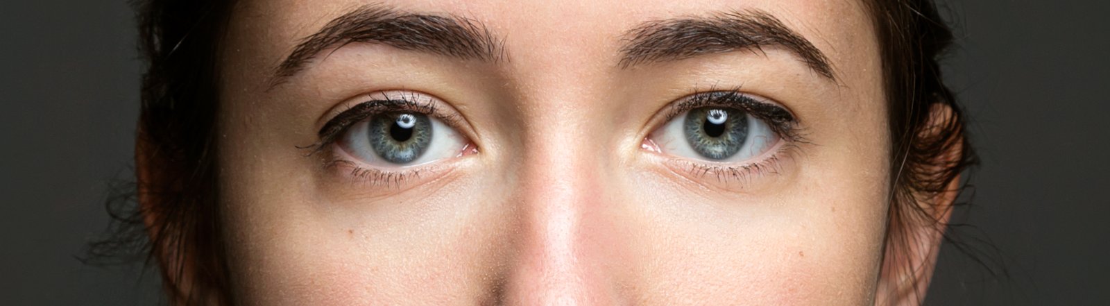 Close-up of calm grey-blue eyes looking straight at the camera