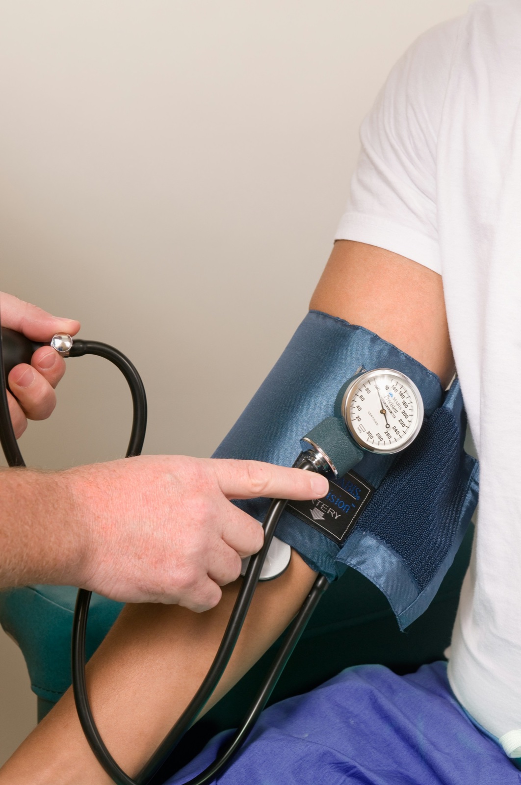 Doctor checking a patient's blood pressure with a cuff and stethoscope