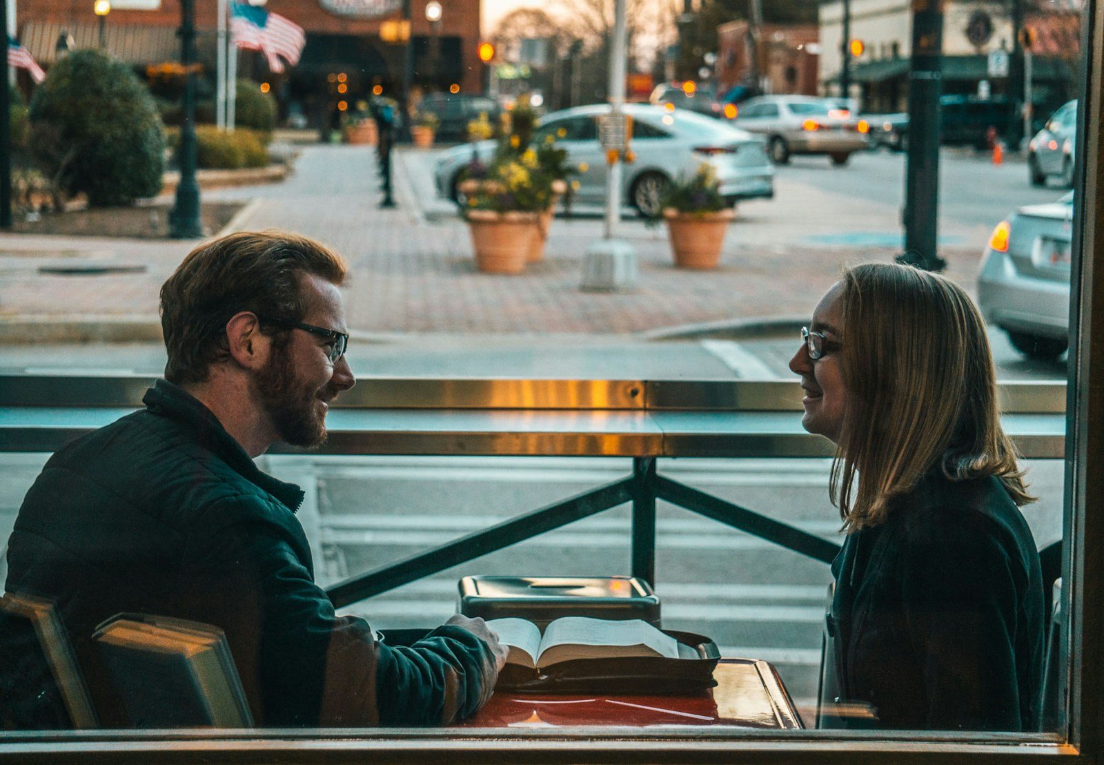 Couple sitting at a café table, looking at each other while they talk