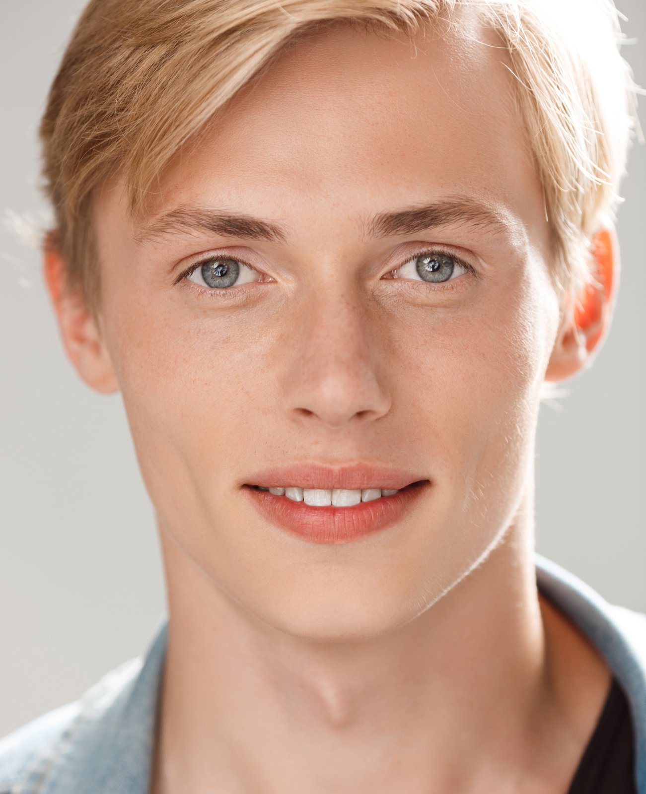 Young man with evenly proportioned features smiling warmly