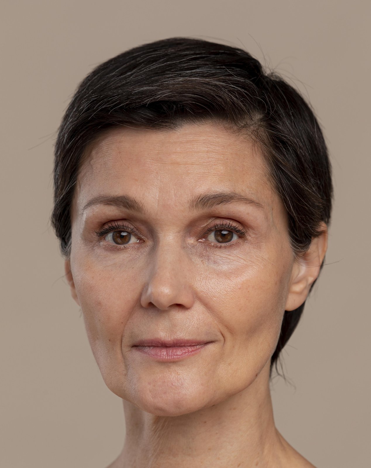 Portrait of a confident middle-aged woman with short dark hair and a calm expression
