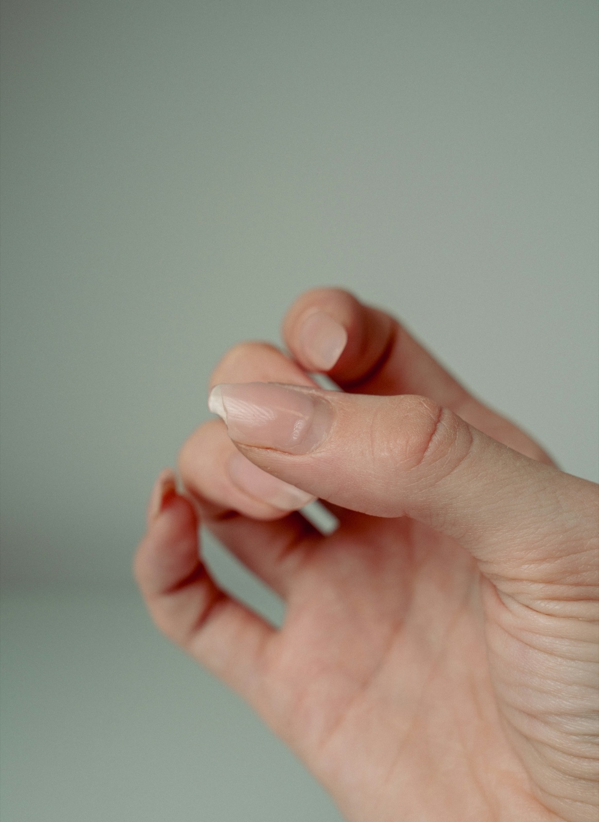 Close-up of a hand with curled fingers showing the fingernails