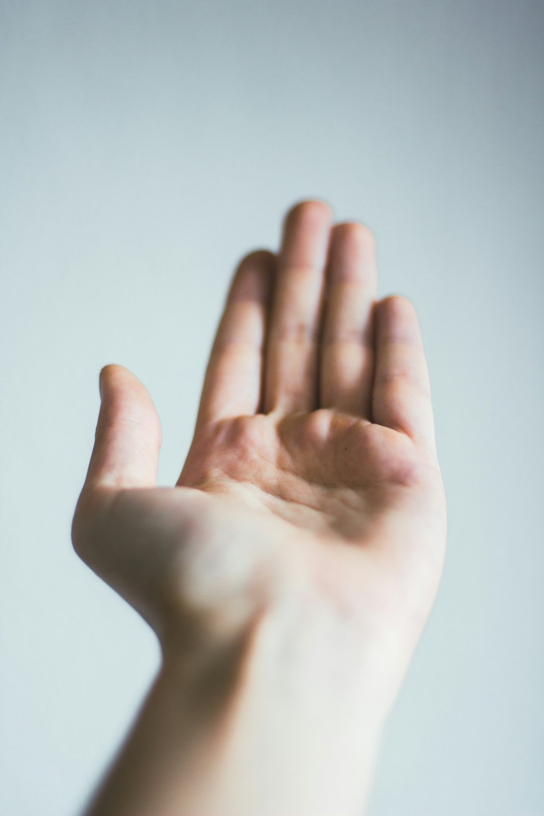 An open palm raised against a pale background