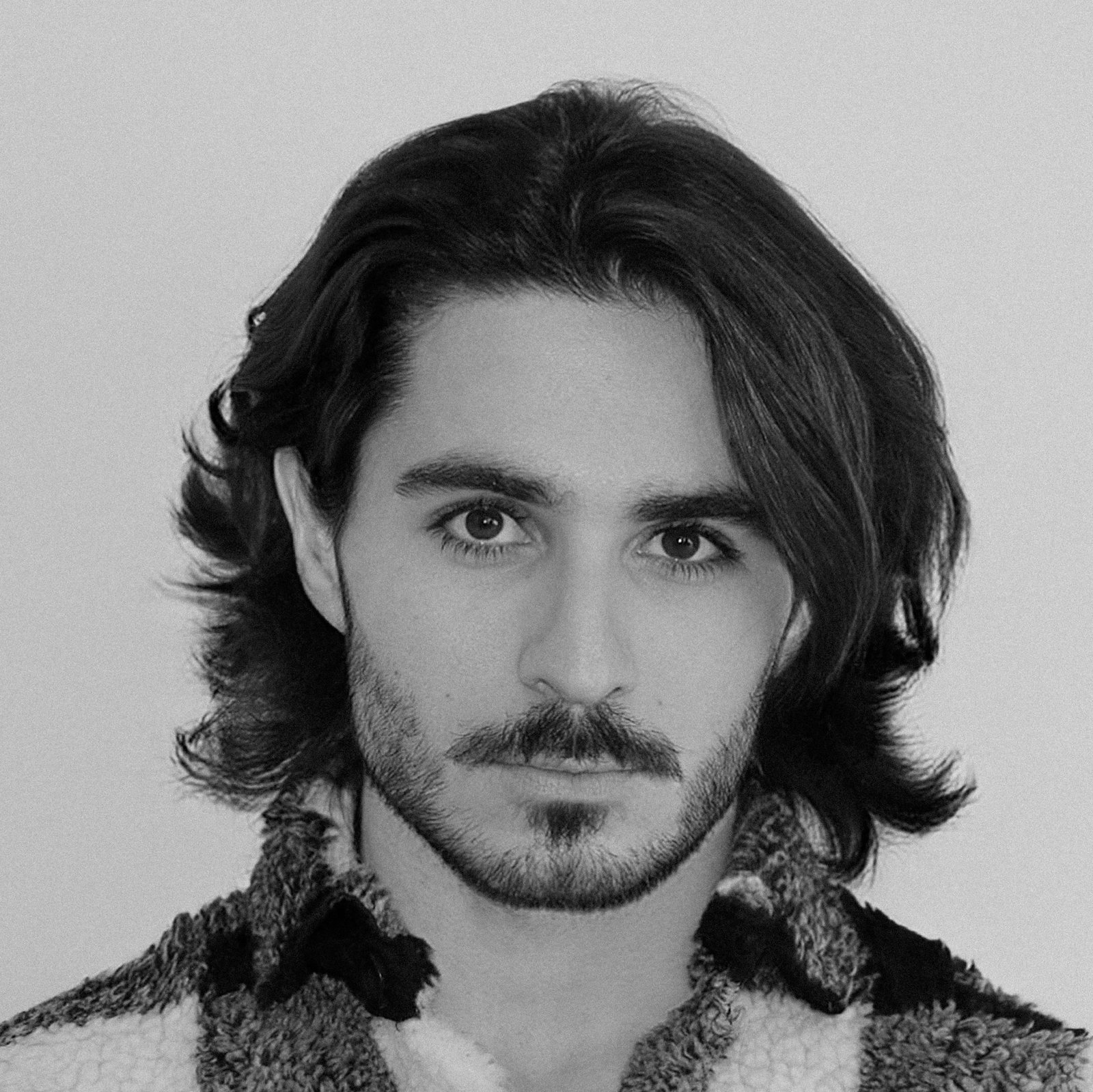 Man with a long, narrow, angular face looking straight at the camera