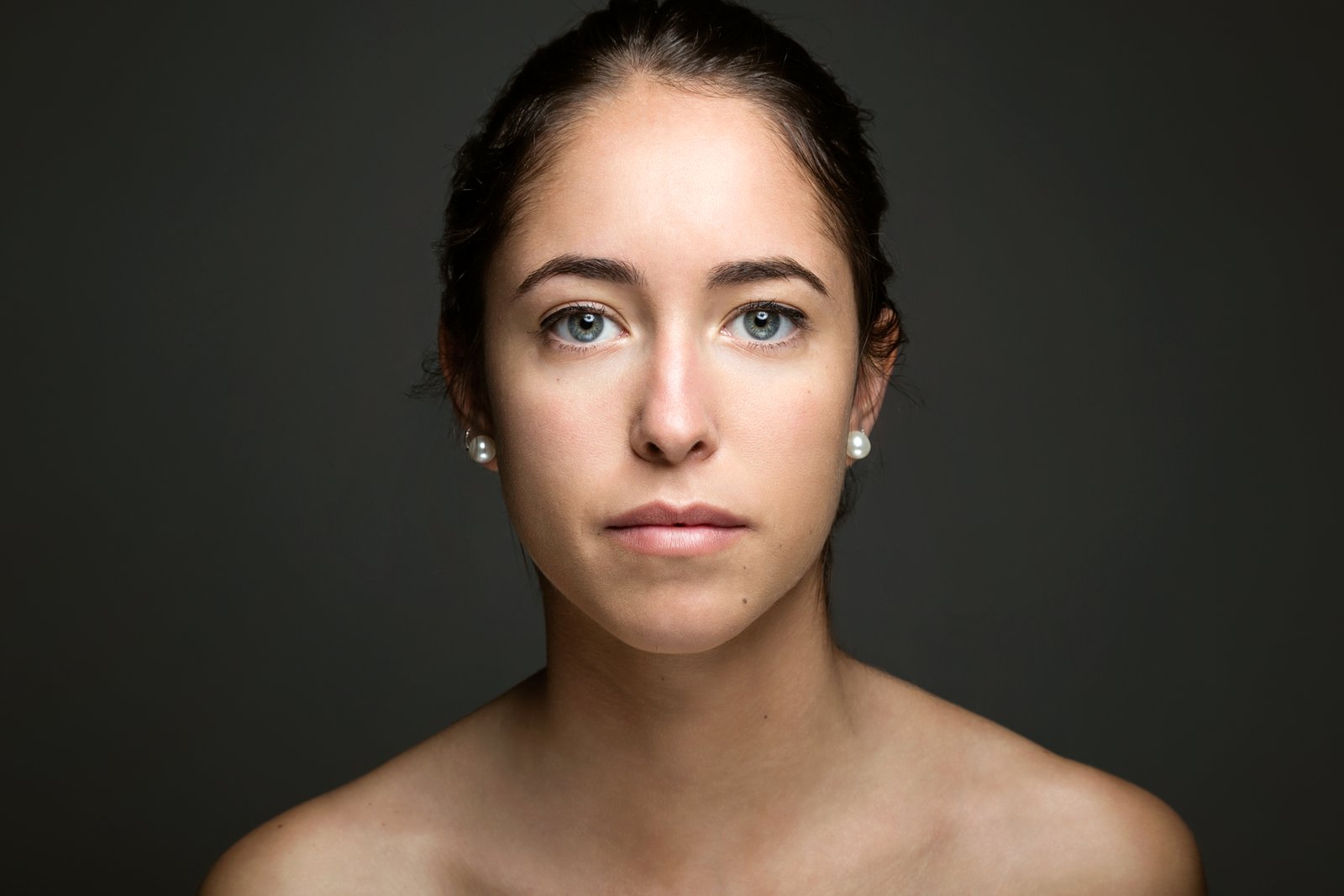 Woman with hair pulled back showing a broad, smooth forehead