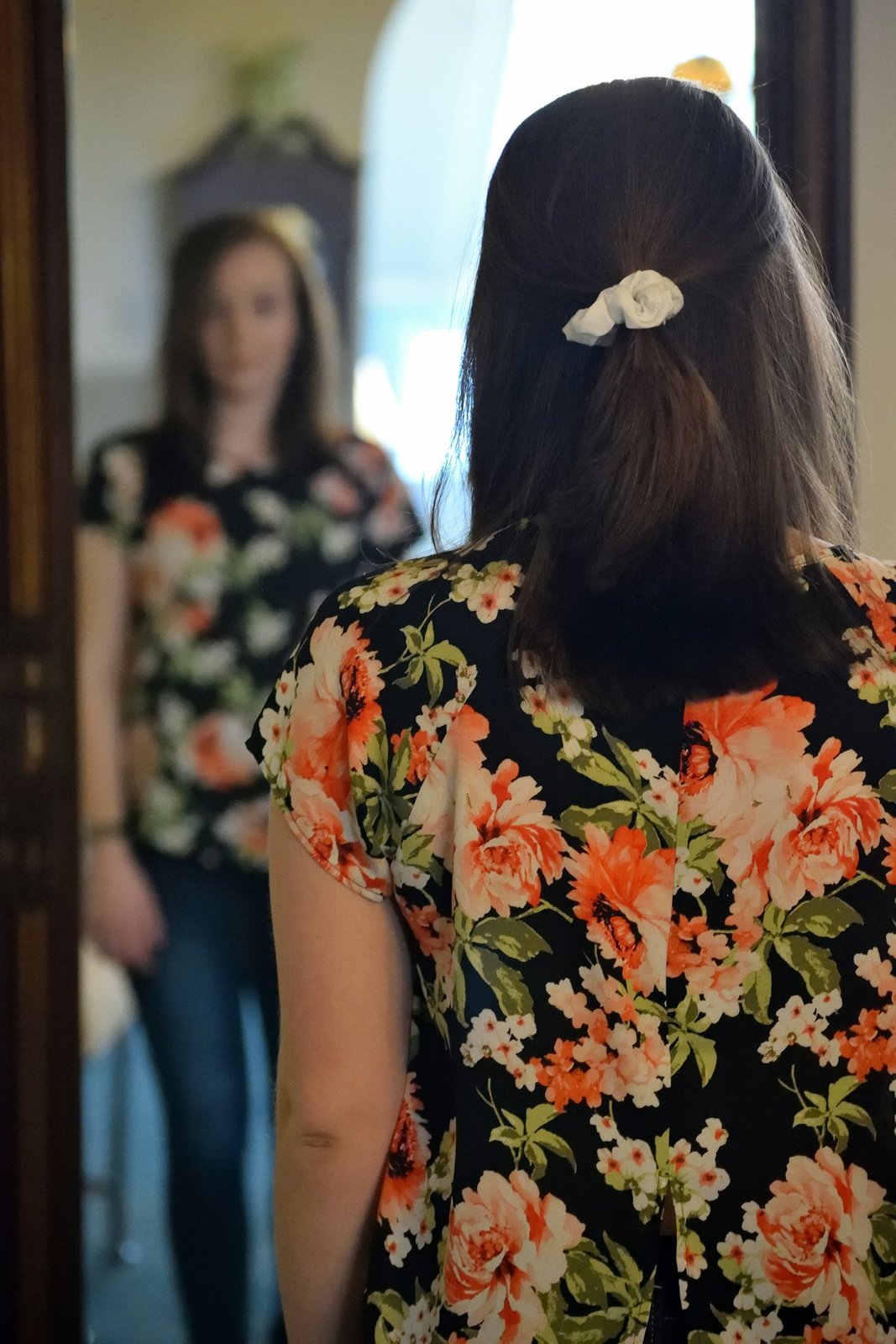 Woman standing in front of a mirror looking at her reflection