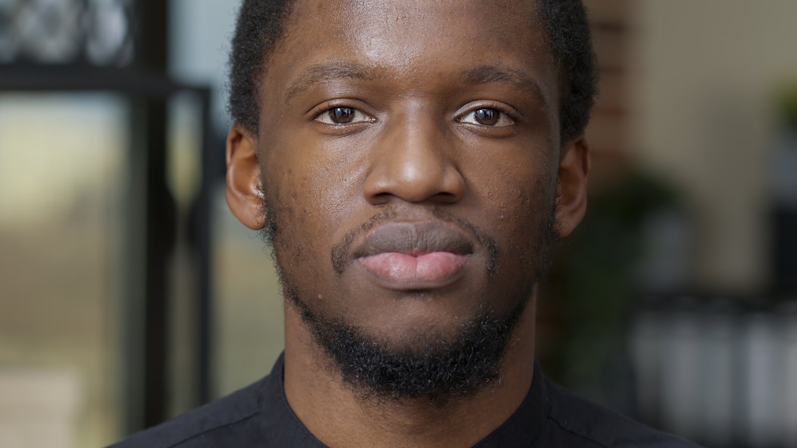 Young man smiling warmly and looking straight at the camera