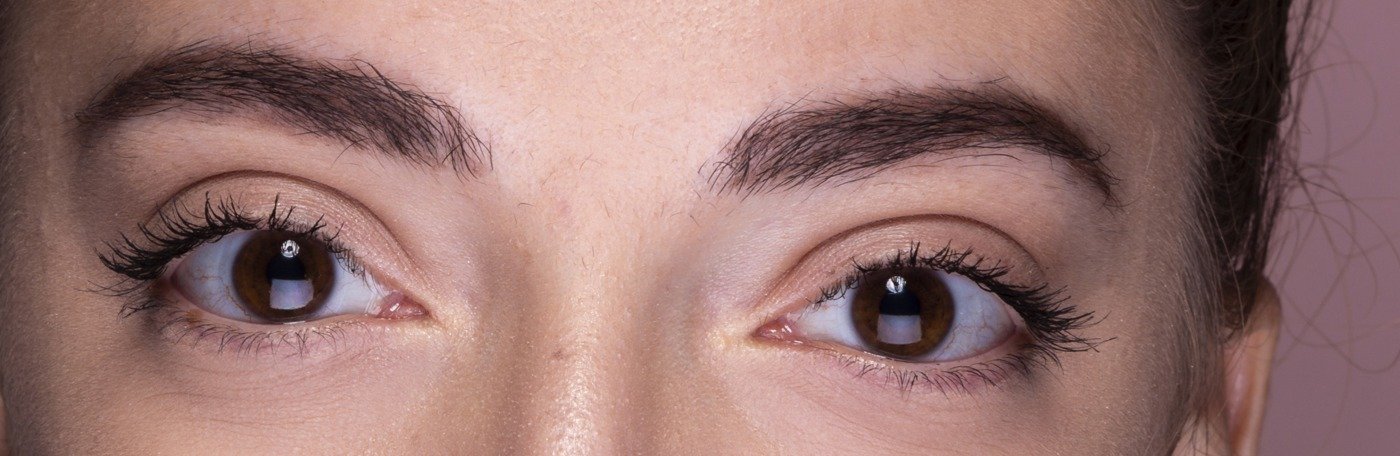 Close-up of arched eyebrows and bright brown eyes