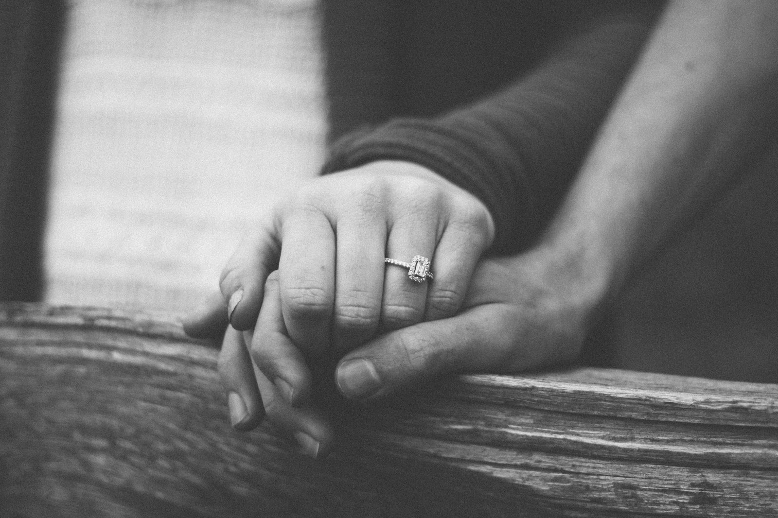 Couple holding hands with an engagement ring visible